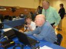 Between sessions with the North Springs students, Mill Springs student Megan Brown, KM4HFY, makes contacts on the HF station under the supervision of Chuck Catledge, AE4CW, and Wes Lamboley, W3WL.